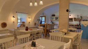 a restaurant with white tables and chairs and a kitchen at Statek Zahrádka Český Krumlov in Český Krumlov