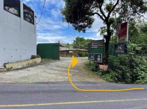a street with a yellow arrow on the road at Pura Natura Lodge in Manuel Antonio