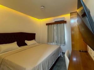 a small bedroom with a bed and a window at Hotel Omega in Oiapoque
