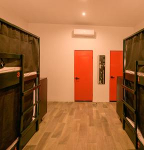 a room with three bunk beds and a red door at Macarena Hostel in Flores