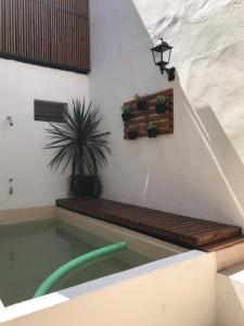 a swimming pool with a bench and a light on a wall at LA CASITA in Buenos Aires