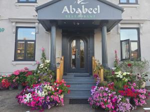 a entrance to a restaurant with flowers in front of it at Ababeel Hotel in Birmingham