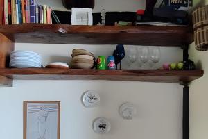 a shelf with plates and glasses on it at Casa Capela - Para quem ama ficar na beira do mar in Marau