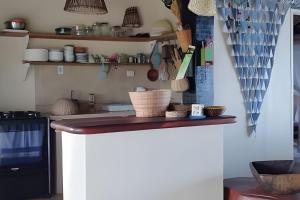 a kitchen with a counter top in a room at Casa Capela - Para quem ama ficar na beira do mar in Marau