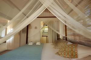 a bedroom with a bed with pillows on it at Casa Capela - Para quem ama ficar na beira do mar in Marau