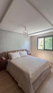 a bedroom with a large bed and a window at Appartement avec balcon vue sur forêt - centre ville in Ifrane