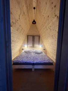 a bed in a wooden room with a window at Castle view Chalet - ZemvaStays in Zgornje Gorje