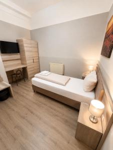a small room with a bed and a desk at Aparthotel Emilia 24h Check-in, Free Parking and WiFi in Bargteheide
