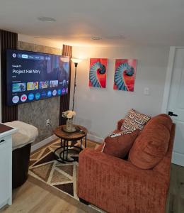 a living room with a couch and a flat screen tv at Ope suites Winnipeg in Winnipeg