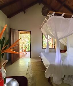 a bedroom with a bed with a white canopy at Licuri Praia de Algodões paz amor na beira do mar in Marau