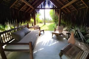 a living room with a couch and chairs on a porch at Licuri Praia de Algodões paz amor na beira do mar in Marau