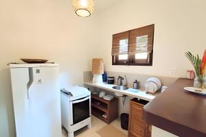 a kitchen with a white refrigerator and a sink at Licuri Praia de Algodões paz amor na beira do mar in Marau +22 photos