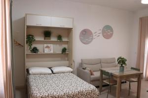 a bedroom with a bed and a table and a couch at Estudio Puerto Isla in Isla Cristina