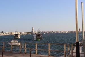 three boats sitting in the water near a dock at Estudio Puerto Isla in Isla Cristina