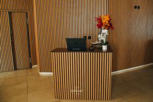 ein Zimmer mit einem Schreibtisch, auf dem ein Laptop und Blumen stehen in der Unterkunft Hotel Liliacul in Cluj-Napoca