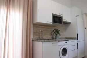 a kitchen with a washing machine and a microwave at Estudio Puerto Isla in Isla Cristina