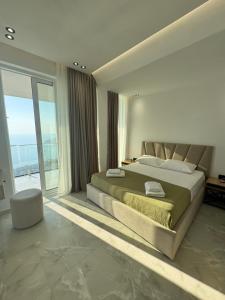 a bedroom with a large bed and a large window at Villa e Diellit in Kaninë