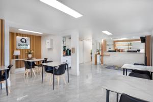 a dining room with tables and chairs and a kitchen at Quality Inn & Suites Silverdale Bangor-Keyport in Silverdale