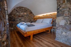 a bed in a room with a stone wall at Sten House in Škofja Loka