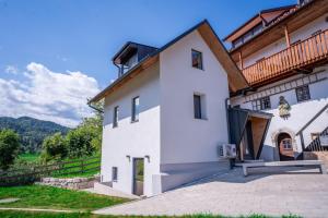 a white house with a wooden roof at Sten House in Škofja Loka