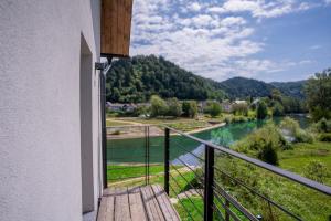 a balcony with a view of a river and mountains at Sten House in Škofja Loka
