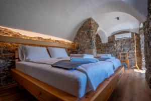 a bedroom with a bed in a stone wall at Sten House in Škofja Loka +17 photos