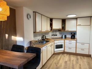 a kitchen with white cabinets and a wooden table at Ferienhaus an der Eder in Edertal