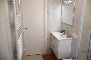 a white bathroom with a sink and a mirror at Casa Riviera Chiara con Parcheggio Privato nel Cuore di Arma in Arma di Taggia
