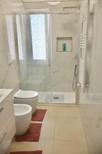 a white bathroom with a shower and a toilet at Casa Riviera Chiara con Parcheggio Privato nel Cuore di Arma in Arma di Taggia