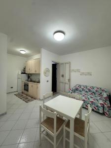 a room with a table and chairs and a bed at Salento Holiday Home in Torre Inserraglio