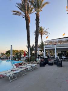 a resort with palm trees and a swimming pool at Salento Holiday Home in Torre Inserraglio