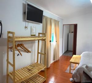 a room with a desk and a television on a wall at El rincón in Merlo