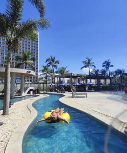 a woman laying on a raft in a pool at a resort at Beach Gav Resort in Ilha de Atalaia