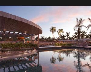 a building with a pool of water with palm trees at Beach Gav Resort in Ilha de Atalaia