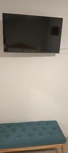 a green bench sitting under a flat screen tv at La casetta di Mercatello in Bagnoregio