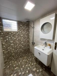 a bathroom with a white sink and a mirror at Beit Rifi Mountain Escape, with intex pool, Feitroun in Al ‘Aqabah