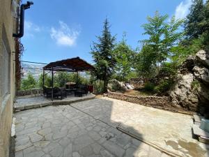 a patio with a gazebo and a table at Beit Rifi Mountain Escape, with intex pool, Feitroun in Al ‘Aqabah