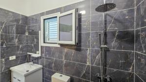 a bathroom with a shower and a window and a toilet at Vila Qetesia in Përmet
