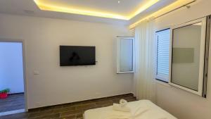 a white room with a tv and a bed at Vila Qetesia in Përmet