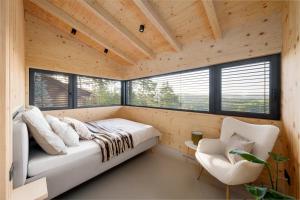 a bedroom with a bed in a room with windows at Sauna House Zelené Údolí in Rabyně