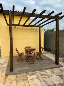 a wooden pergola with a table and chairs on a patio at pousada ilha do amor in Barreirinhas