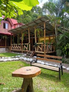 a bench and a table in front of a building at Montañita Lodge in La Merced