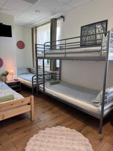 a room with three bunk beds and a rug at Pokoje Tanie Spanie in Zator