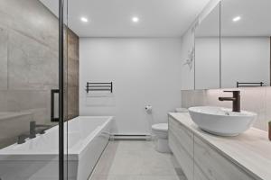 a bathroom with a sink and a tub and a toilet at Unit 178 - 4 bedrooms - Sleeps 8 in Beaupré +15 photos