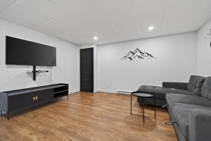 a living room with a couch and a flat screen tv at Unit 178 - 4 bedrooms - Sleeps 8 in Beaupré