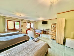 a bedroom with two beds and a living room at Lavanda Vendégház in Németkér