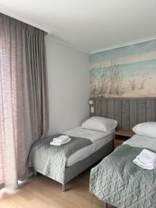 a bedroom with two beds and a painting on the wall at Port Rewa in Rewa