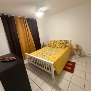 a bedroom with a bed with yellow sheets and curtains at Villa Floru in Le Carbet