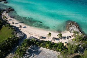an aerial view of a beach with palm trees and the ocean at The Anchorage at Rainbow Bay, Eleuthera in Hatchet Bay Limited Settlement