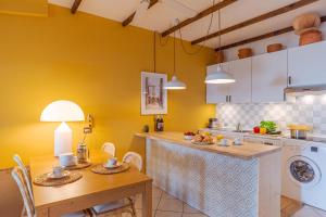 a kitchen with yellow walls and a table with chairs at Brentano Giardino in Mezzegra